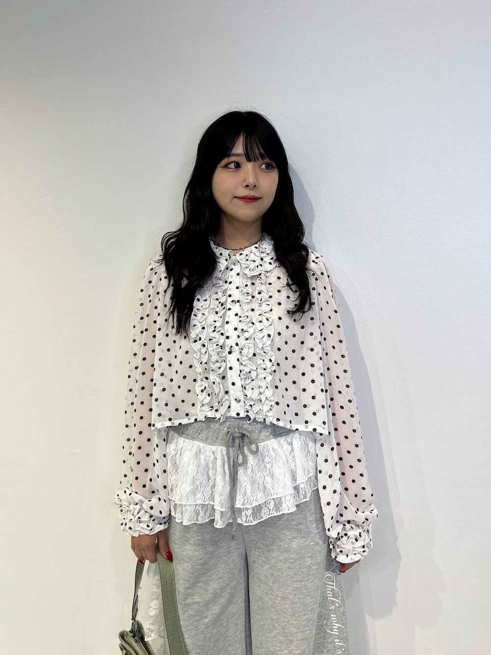 グレー系のスウェットパンツ、ブラック系のローファー、グリーン系のハンドバッグを着用したレディースの秋コーディネートの4枚目の写真