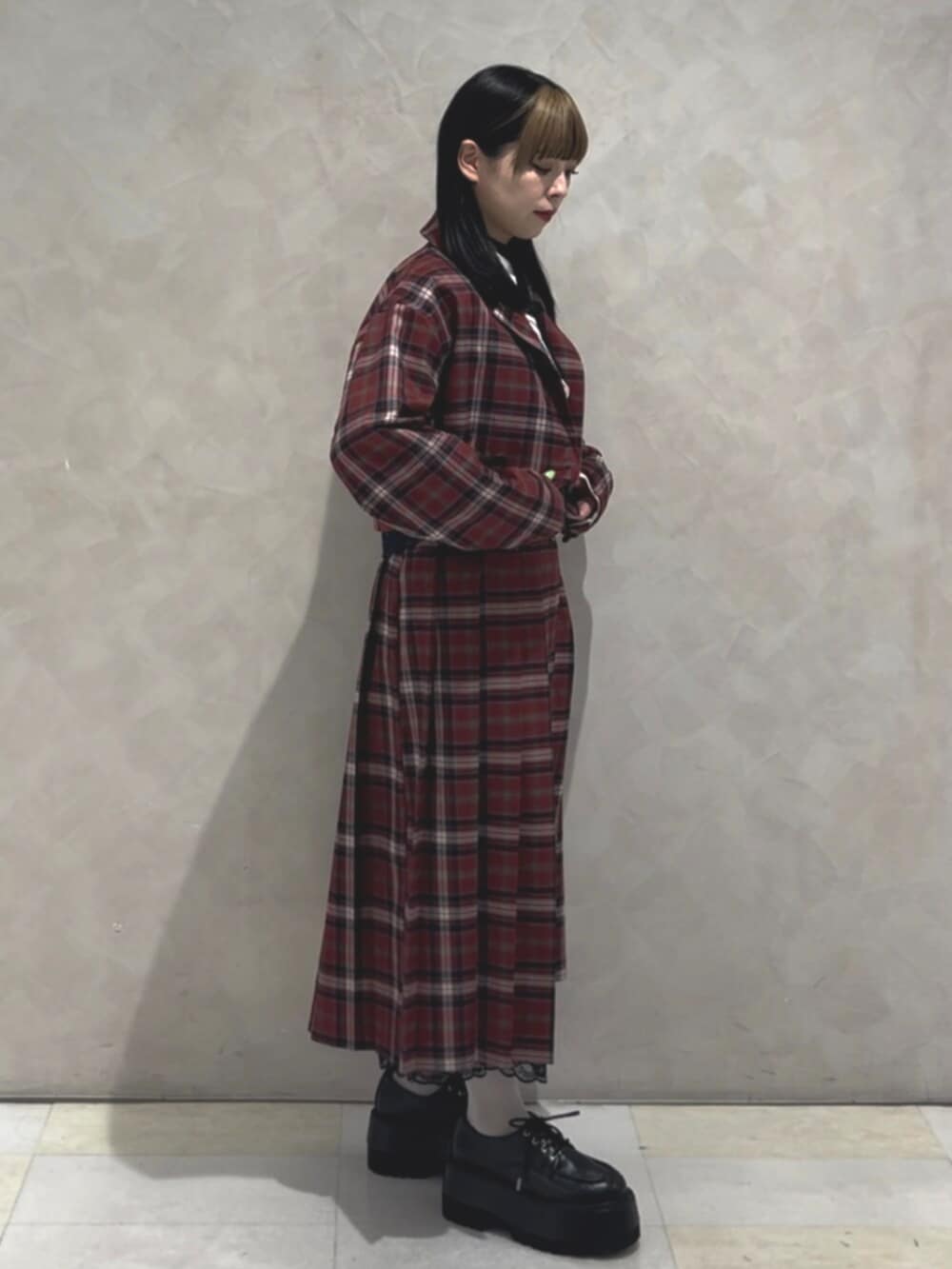 ブラック系のドレスシューズ、ホワイト系のシャツ/ブラウス、レッド系のスカートを着用したレディースの冬コーディネートの3枚目の写真