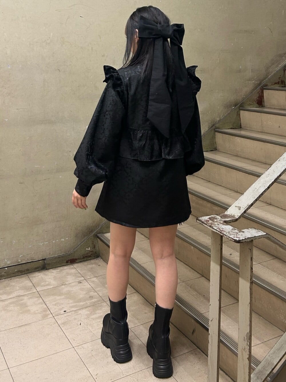 ブラック系のブーツ、ブラック系のシャツ/ブラウス、ブラック系のバレッタ/ヘアクリップを着用したレディースの冬コーディネートの3枚目の写真