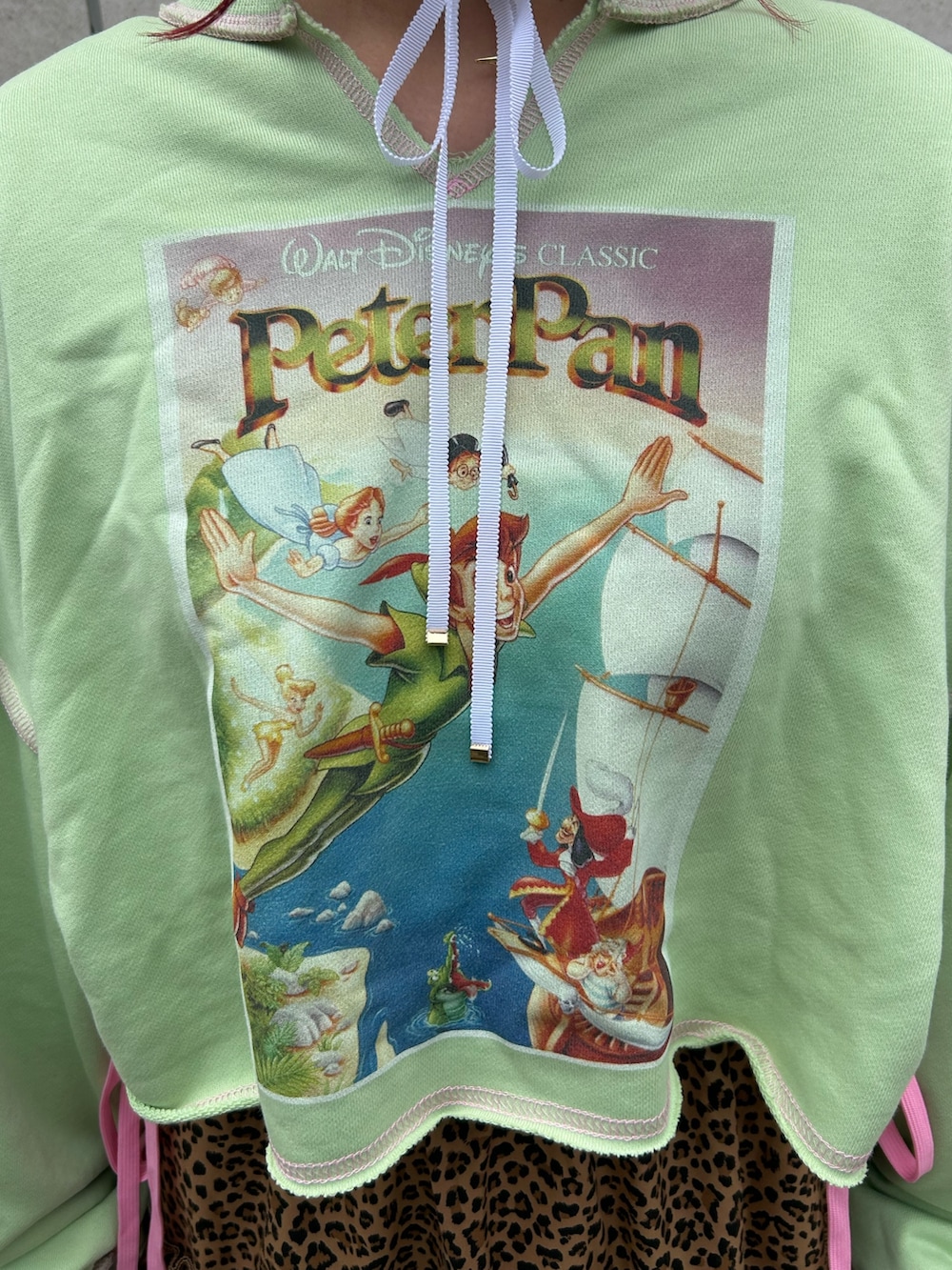 ブラウン系のスカート、グリーン系のスウェット、ブラック系のブーツを着用したレディースの夏コーディネートの5枚目の写真