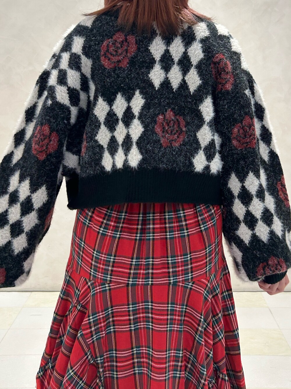 レッド系のスカート、ブラック系のドレスシューズ、ブラック系のカーディガン/ボレロを着用したレディースの秋コーディネートの6枚目の写真