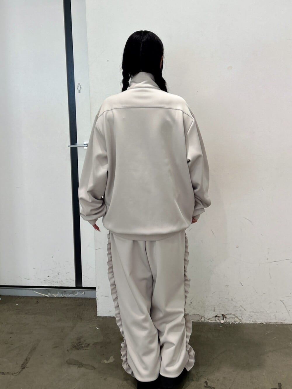 ブラック系のブーツ、ホワイト系のジャージ、ホワイト系のその他パンツを着用したレディースの秋コーディネートの3枚目の写真