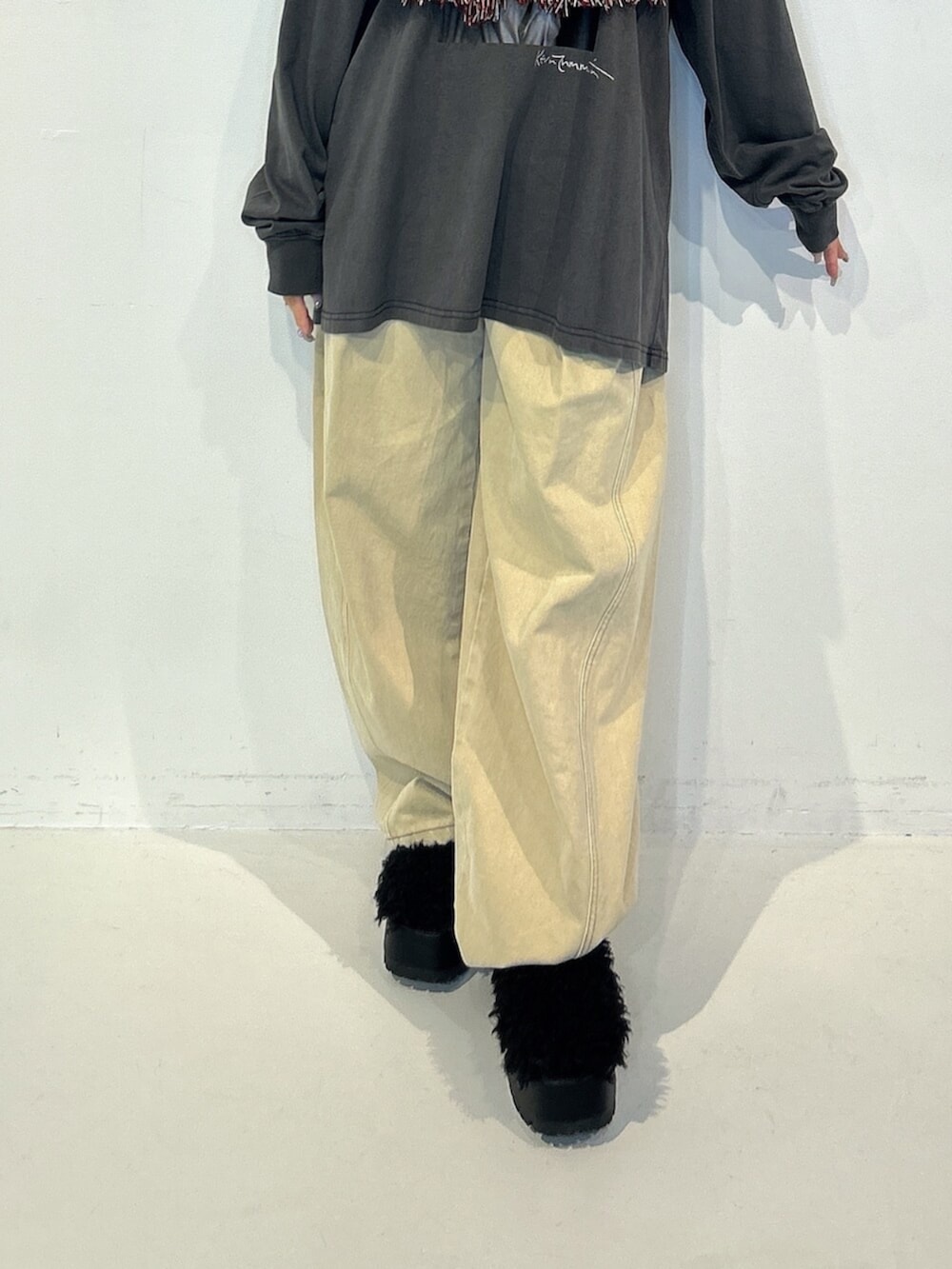 ブラック系のサンダル、ブラック系のTシャツ/カットソー、ベージュ系のデニムパンツを着用したレディースの秋コーディネートの5枚目の写真