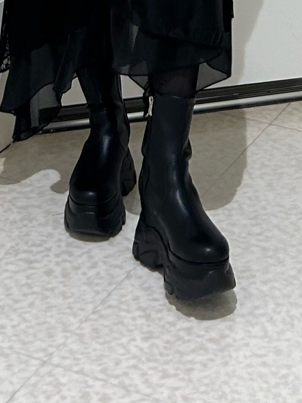 ホワイト系のニット/セーター、ブルー系のシャツ/ブラウス、ブラック系のブーツを着用したレディースの冬コーディネートの7枚目の写真