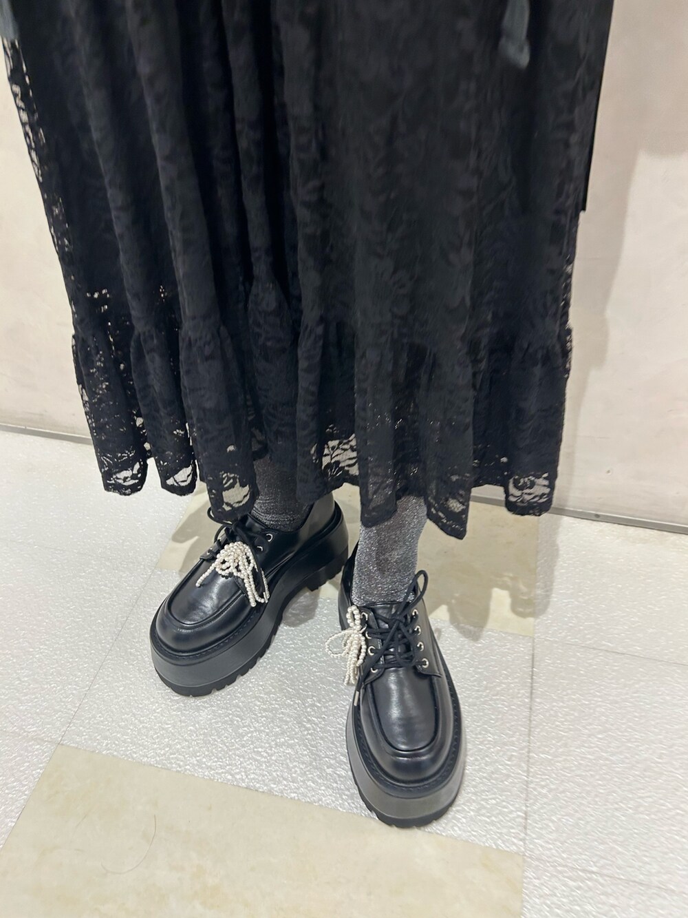 ブラック系のスカート、ブラック系のドレスシューズ、ホワイト系のシューズ小物/雑貨を着用したレディースの秋コーディネートの9枚目の写真