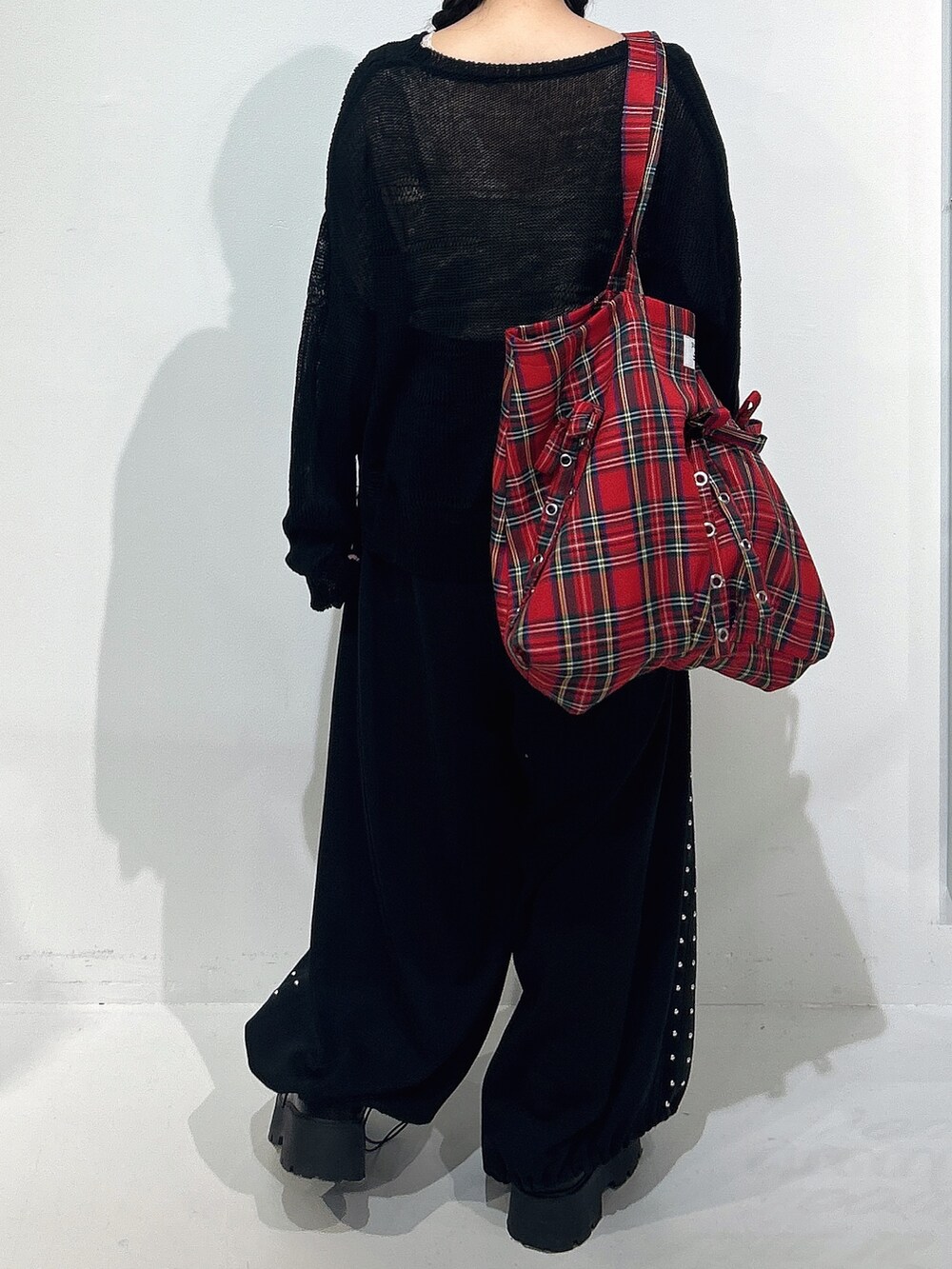 ブラック系のニット/セーター、ブラック系のスウェットパンツ、ブラック系のローファーを着用したレディースの冬コーディネートの3枚目の写真