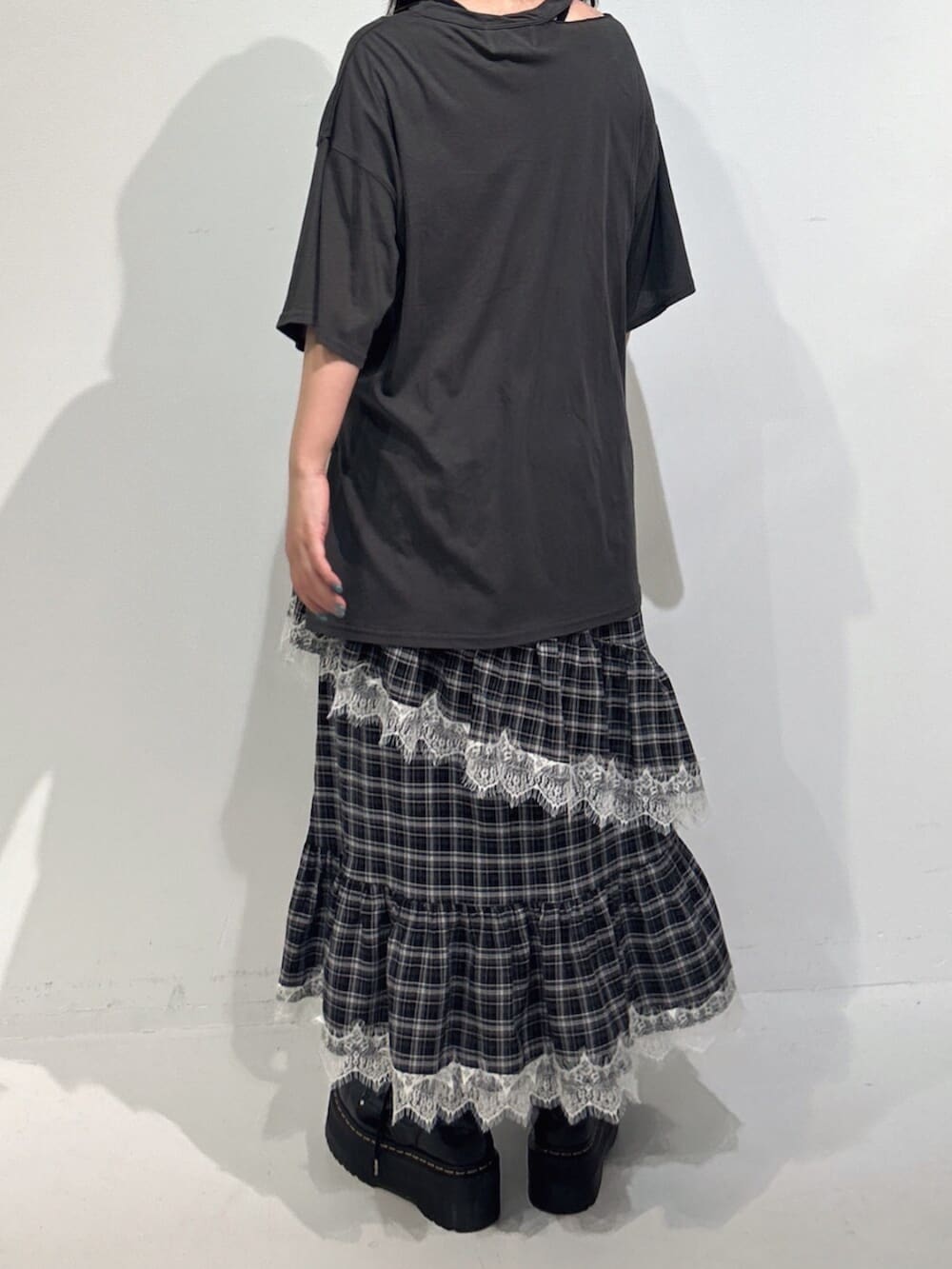 ブラック系のハンドバッグ、ブラック系のブーツ、グレー系のワンピースを着用したレディースの冬コーディネートの3枚目の写真