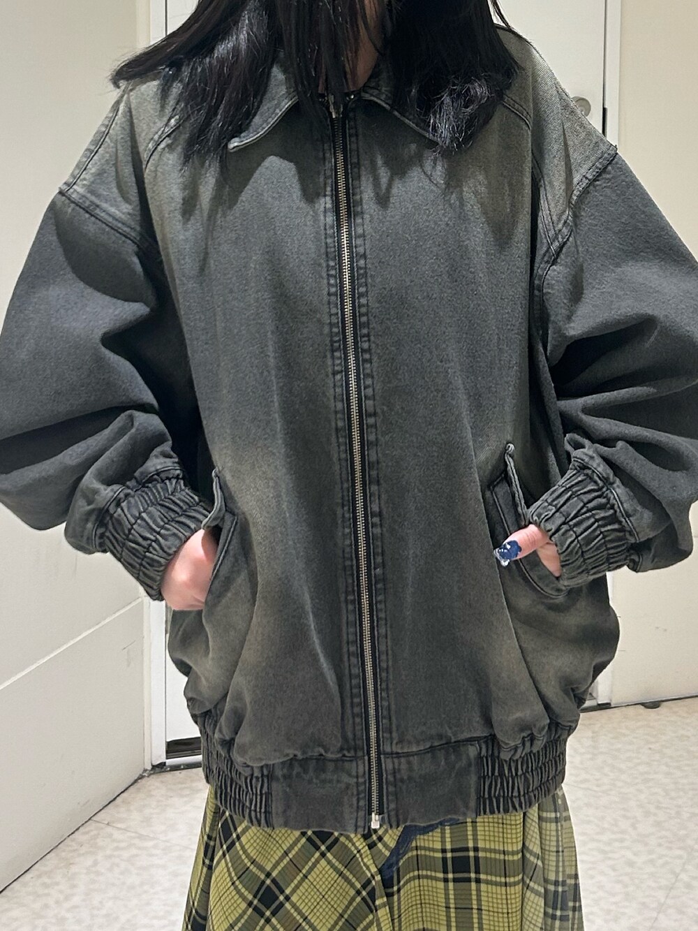 ブラック系のデニムジャケット、イエロー系のスカート、ブラック系のブーツを着用したレディースの春コーディネートの5枚目の写真