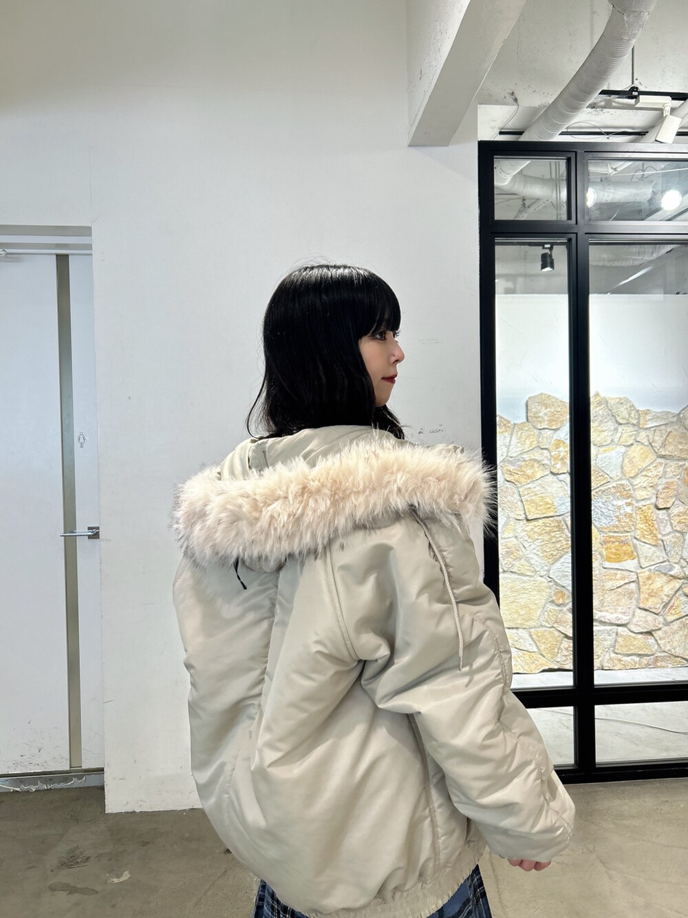 ブラック系のニット/セーター、ブルー系のスカート、ブラック系のブーツを着用したレディースの秋コーディネートの4枚目の写真