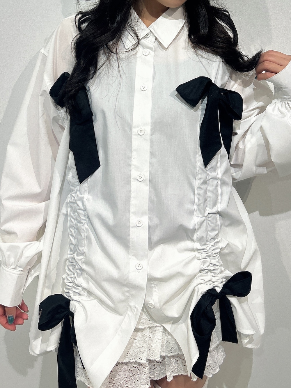 ホワイト系のシャツ/ブラウス、ホワイト系のスカート、ブラック系のブーツを着用したレディースの冬コーディネートの4枚目の写真