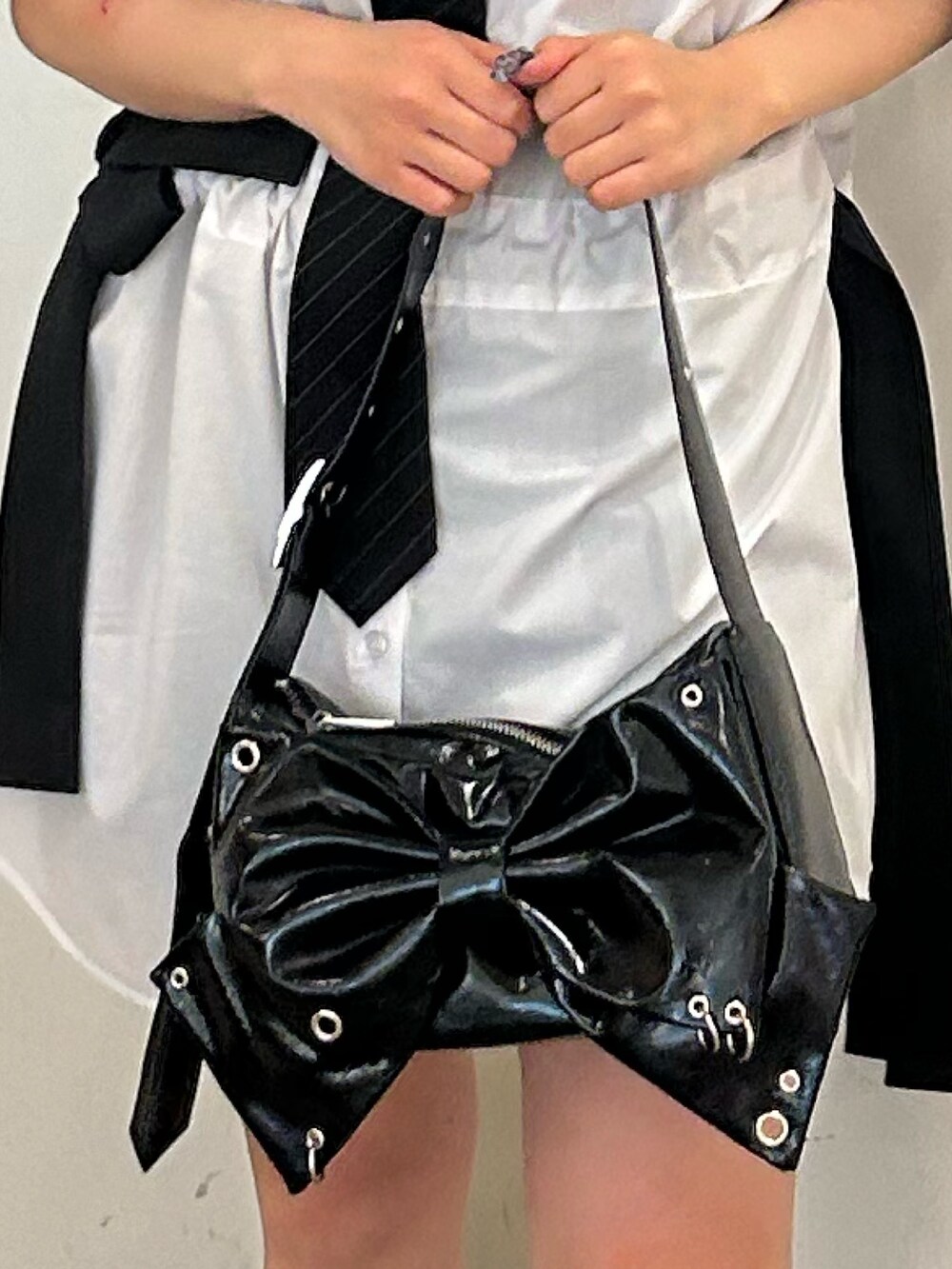 ホワイト系のシャツ/ブラウス、ブラック系のネクタイ、ブラック系のブーツを着用したレディースの春コーディネートの7枚目の写真