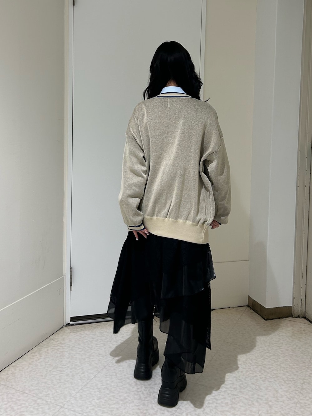 ホワイト系のニット/セーター、ブルー系のシャツ/ブラウス、ブラック系のブーツを着用したレディースの冬コーディネートの3枚目の写真