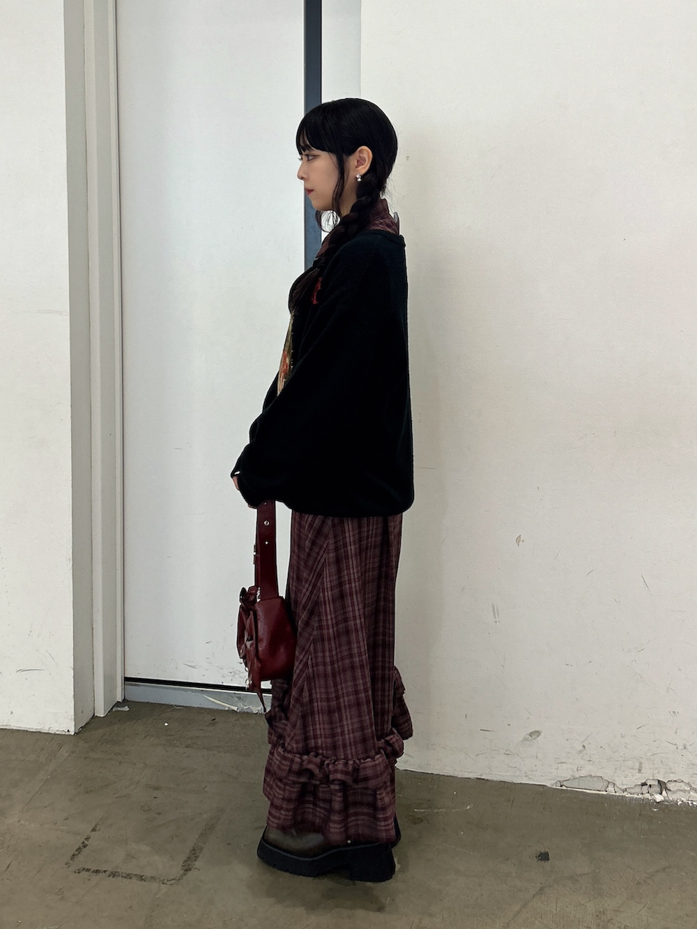 ブラック系のニット/セーター、レッド系のワンピース、レッド系のショルダーバッグを着用したレディースの秋コーディネートの2枚目の写真