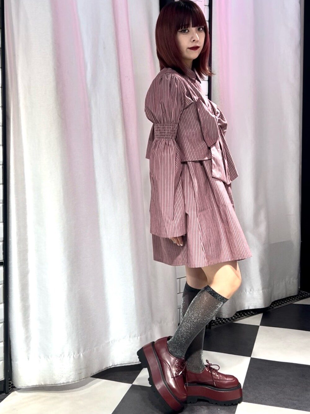 レッド系のシャツワンピース、レッド系のドレスシューズ、ゴールド系のブレスレットを着用したレディースの夏コーディネートの4枚目の写真