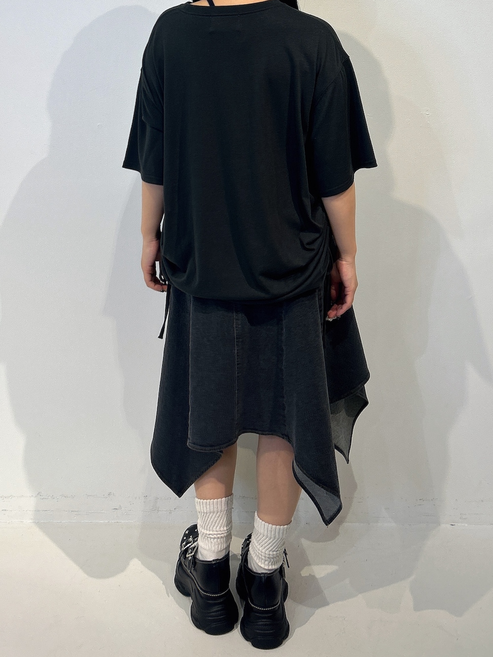 ブラック系のTシャツ/カットソー、ブラック系のスカート、ブラック系のサンダルを着用したレディースの春コーディネートの3枚目の写真