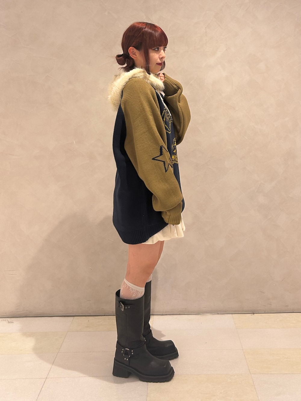 ブラック系のブーツ、ホワイト系のスカート、ブルー系のニット/セーターを着用したレディースの秋コーディネートの2枚目の写真