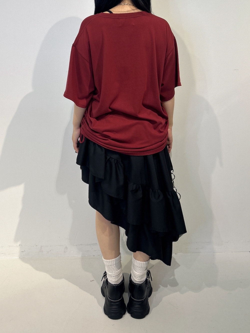 レッド系のTシャツ/カットソー、ブラック系のスカート、ブラック系のハンドバッグを着用したレディースの春コーディネートの3枚目の写真