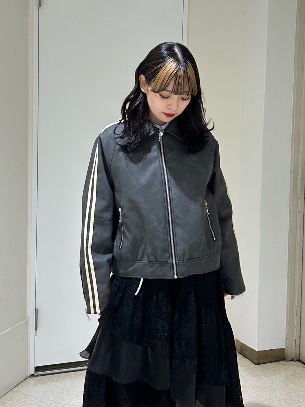 ブラック系のブルゾン、ブラック系のスカート、ブラック系のブーツを着用したレディースの冬コーディネートの4枚目の写真