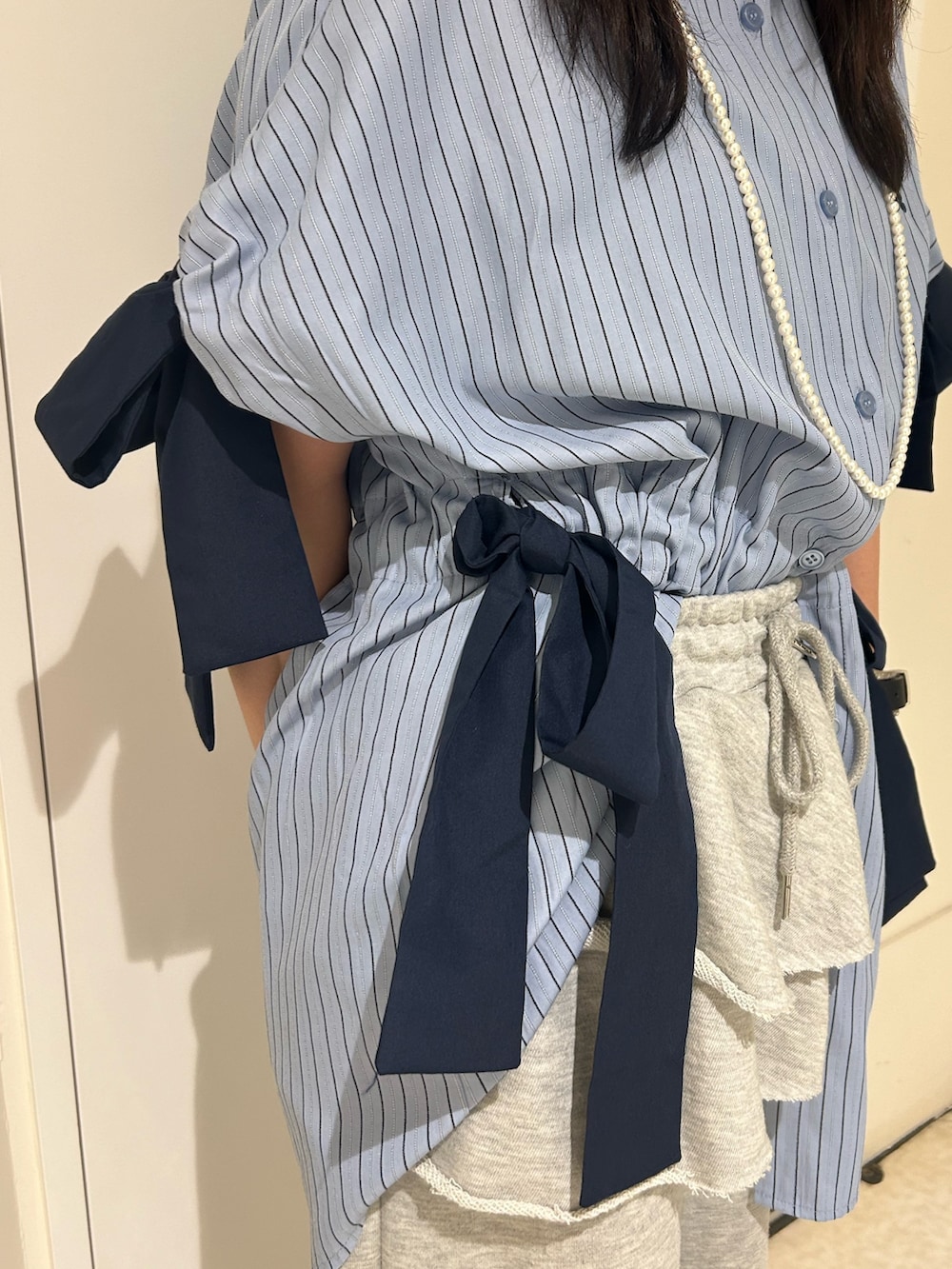 ブルー系のシャツ/ブラウス、グレー系のスウェットパンツ、ブラック系のその他シューズを着用したレディースの夏コーディネートの5枚目の写真