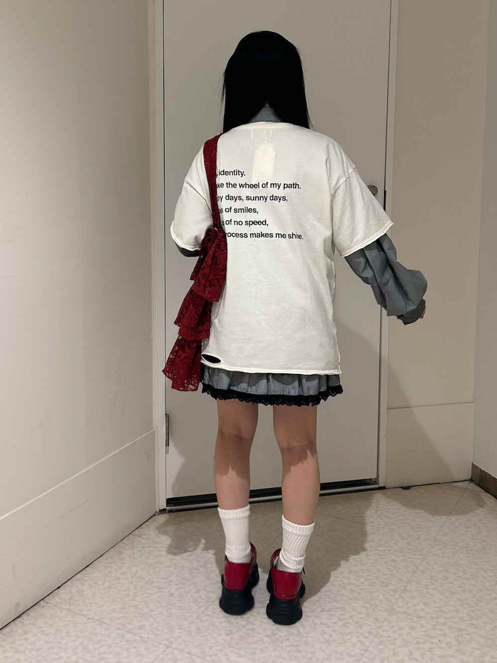 ホワイト系のTシャツ/カットソー、レッド系のスニーカー、レッド系のトートバッグを着用したレディースの春コーディネートの4枚目の写真
