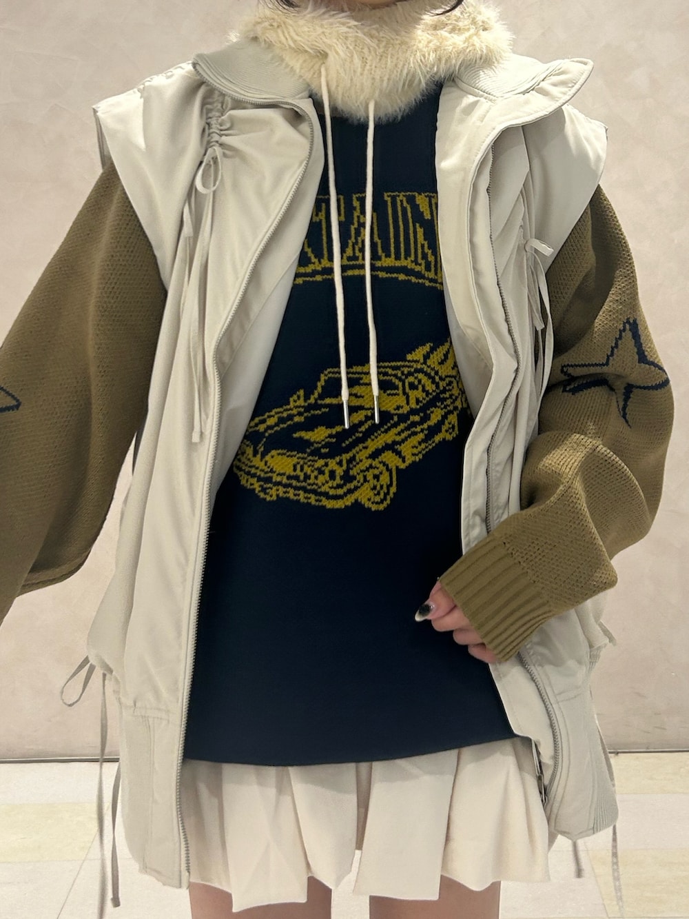 ブルー系のニット/セーター、ホワイト系のスカート、ホワイト系のダウンベストを着用したレディースの冬コーディネートの4枚目の写真