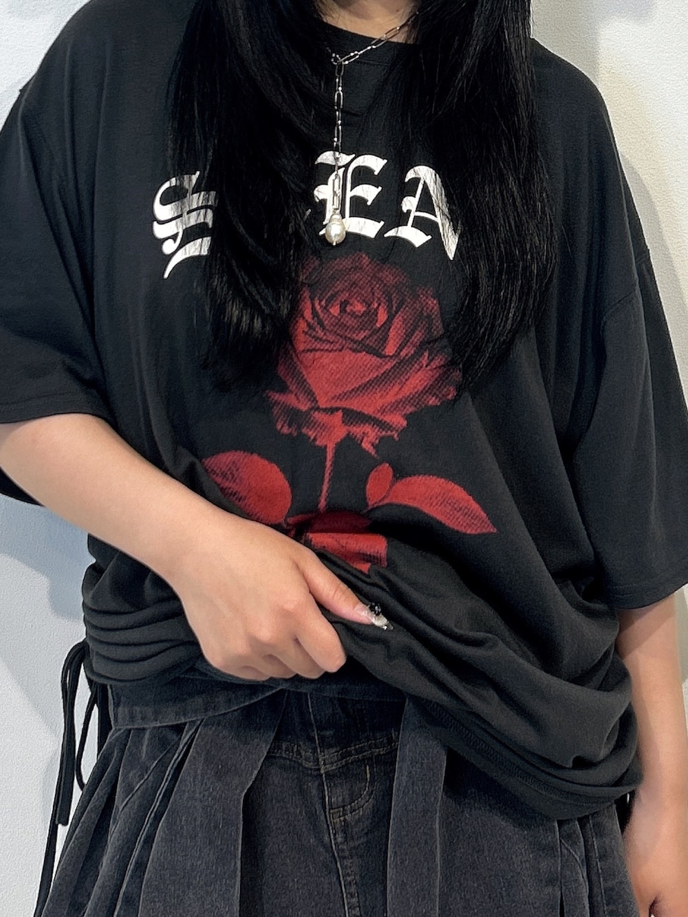 ブラック系のTシャツ/カットソー、ブラック系のスカート、ブラック系のサンダルを着用したレディースの春コーディネートの5枚目の写真