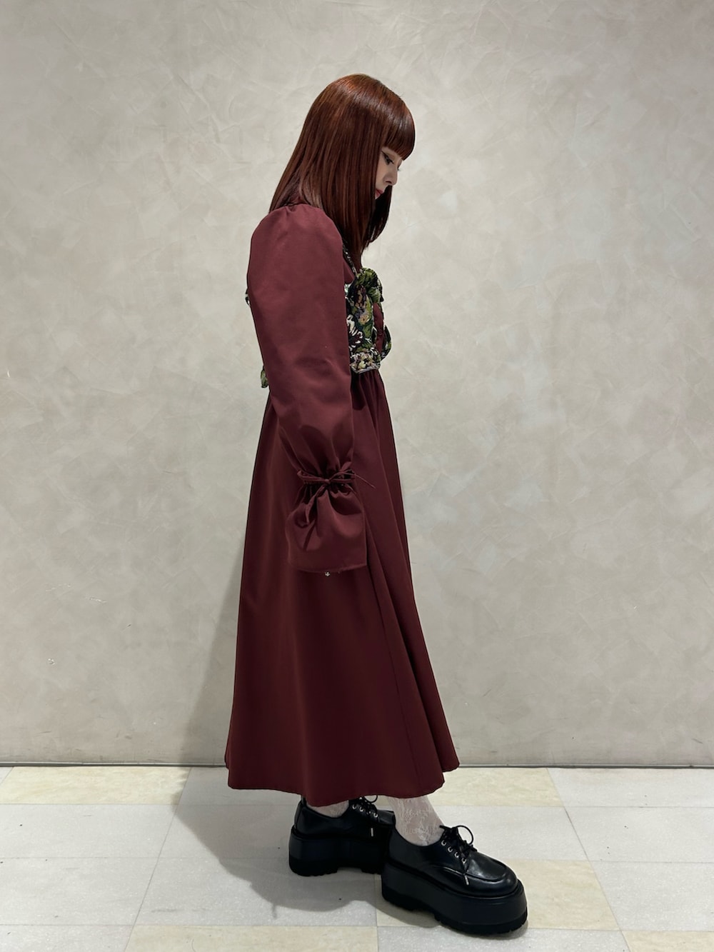 レッド系のワンピース、ブラック系のドレスシューズを着用したレディースの秋コーディネートの2枚目の写真