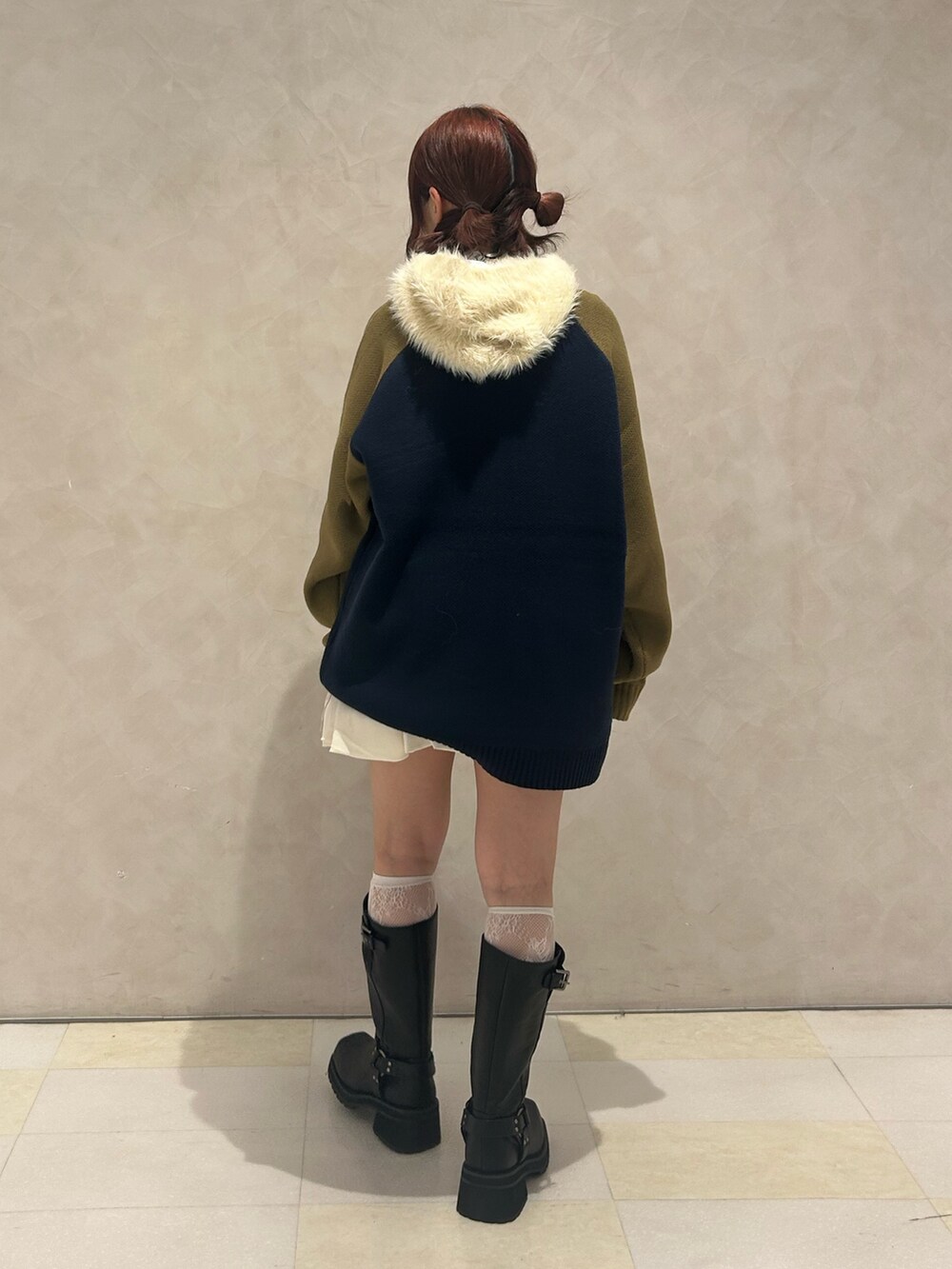 ブラック系のブーツ、ホワイト系のスカート、ブルー系のニット/セーターを着用したレディースの秋コーディネートの3枚目の写真