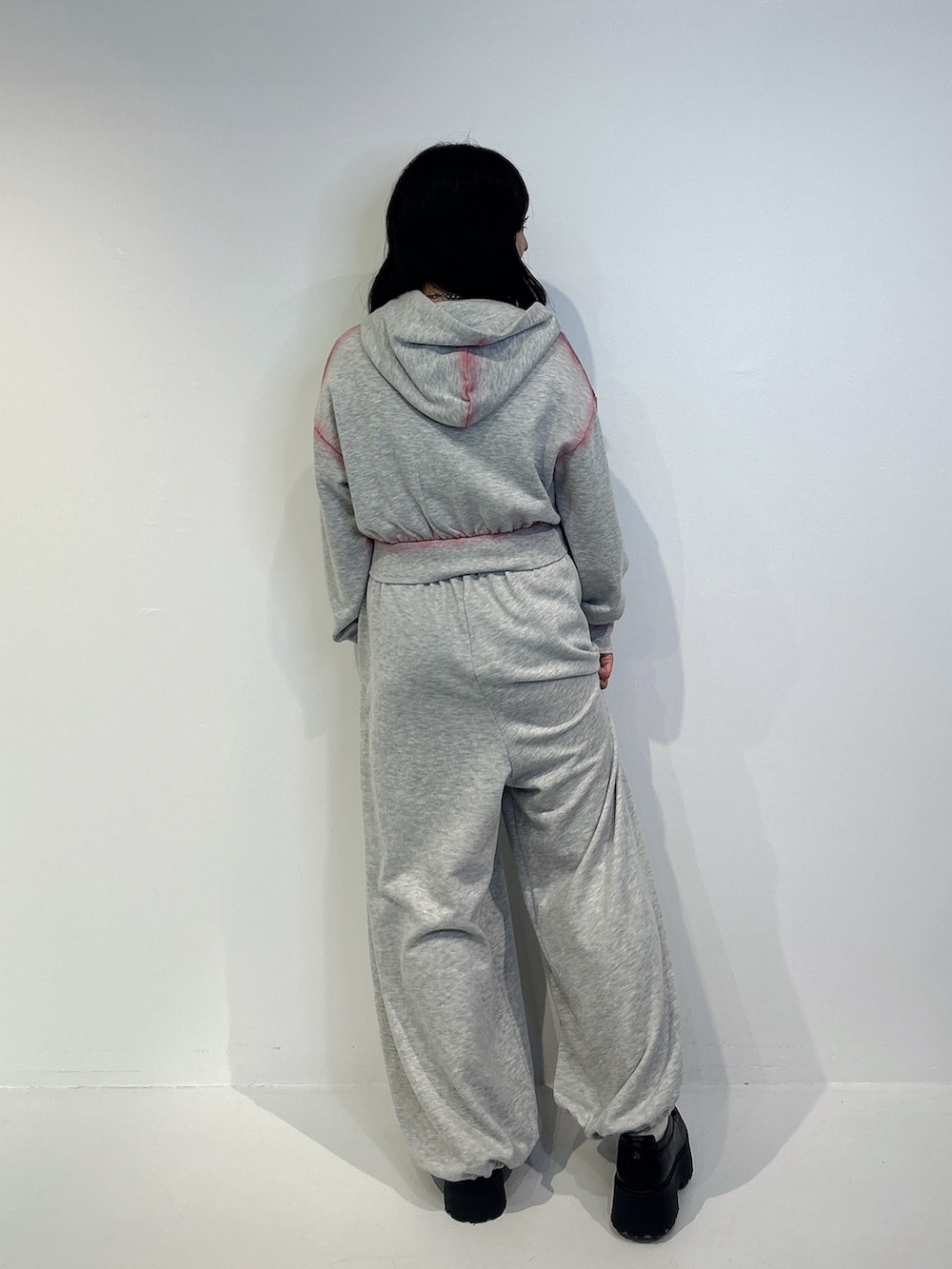 グレー系のパーカー、グレー系のスウェットパンツ、ブラック系のローファーを着用したレディースの冬コーディネートの3枚目の写真