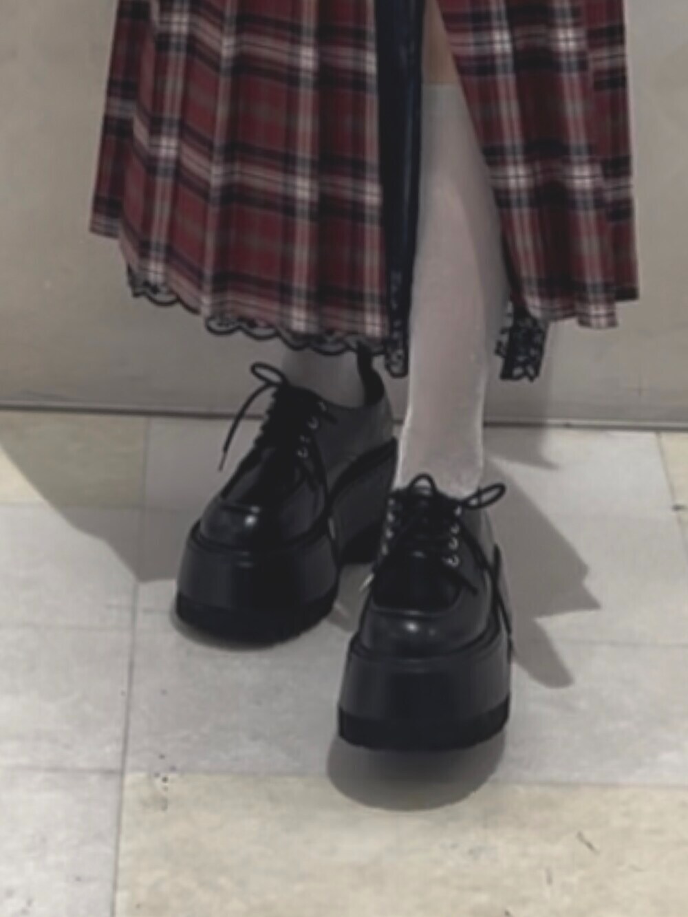 ブラック系のドレスシューズ、ホワイト系のシャツ/ブラウス、レッド系のスカートを着用したレディースの冬コーディネートの9枚目の写真