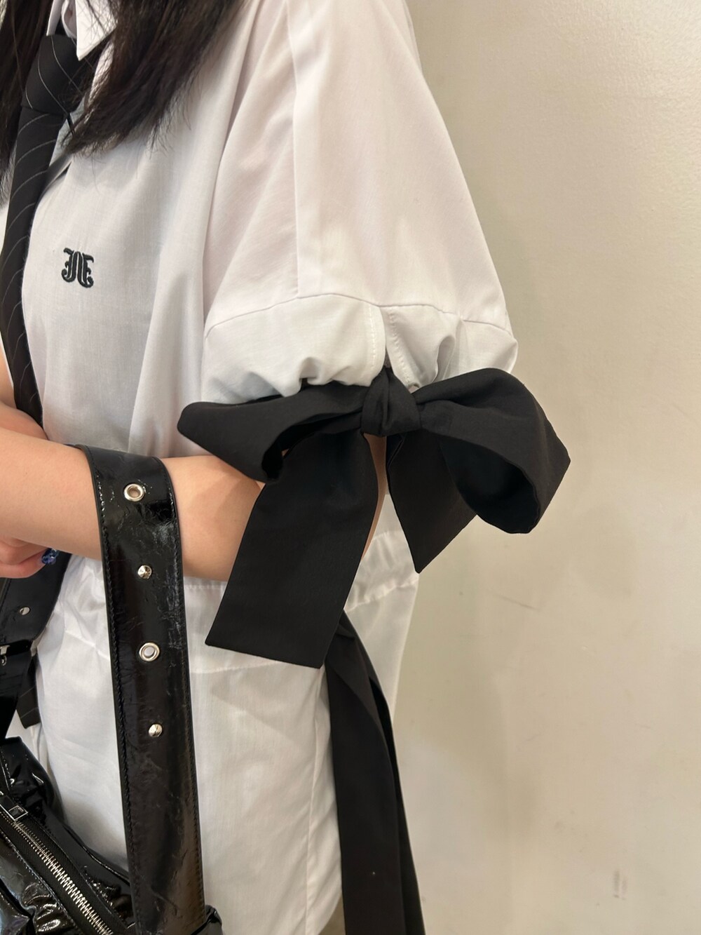ホワイト系のシャツ/ブラウス、ブラック系のネクタイ、ブラック系のブーツを着用したレディースの春コーディネートの5枚目の写真