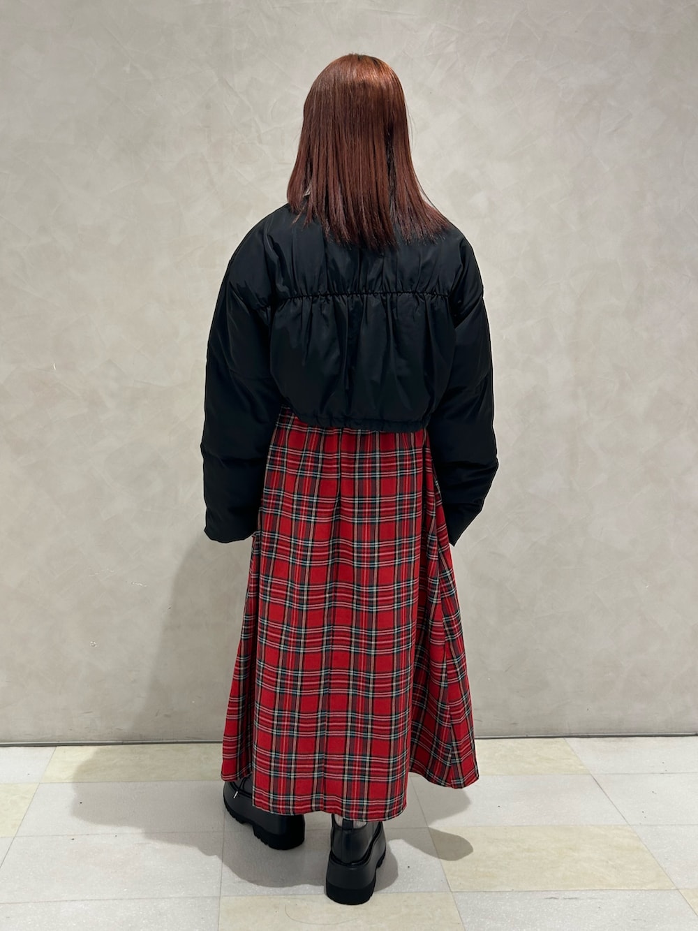 レッド系のワンピース、ブラック系のブルゾン、ブラック系のドレスシューズを着用したレディースの冬コーディネートの3枚目の写真