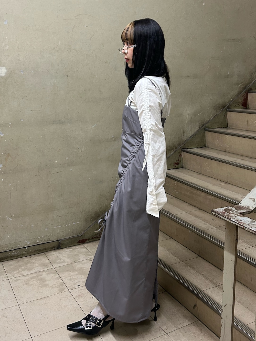 グレー系のワンピース、ホワイト系のシャツ/ブラウス、ブラック系のパンプスを着用したレディースの冬コーディネートの2枚目の写真