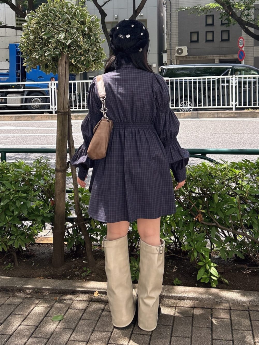 ブルー系のシャツ/ブラウス、ホワイト系のブーツ、ブラウン系のハンドバッグを着用したレディースの夏コーディネートの3枚目の写真