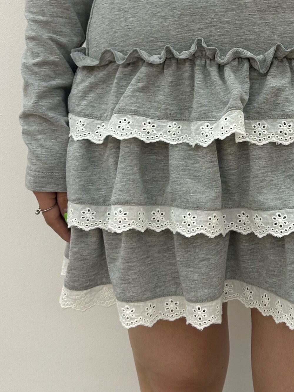 グレー系のワンピース、ブラック系のブーツ、ブルー系のチョーカーを着用したレディースの冬コーディネートの5枚目の写真