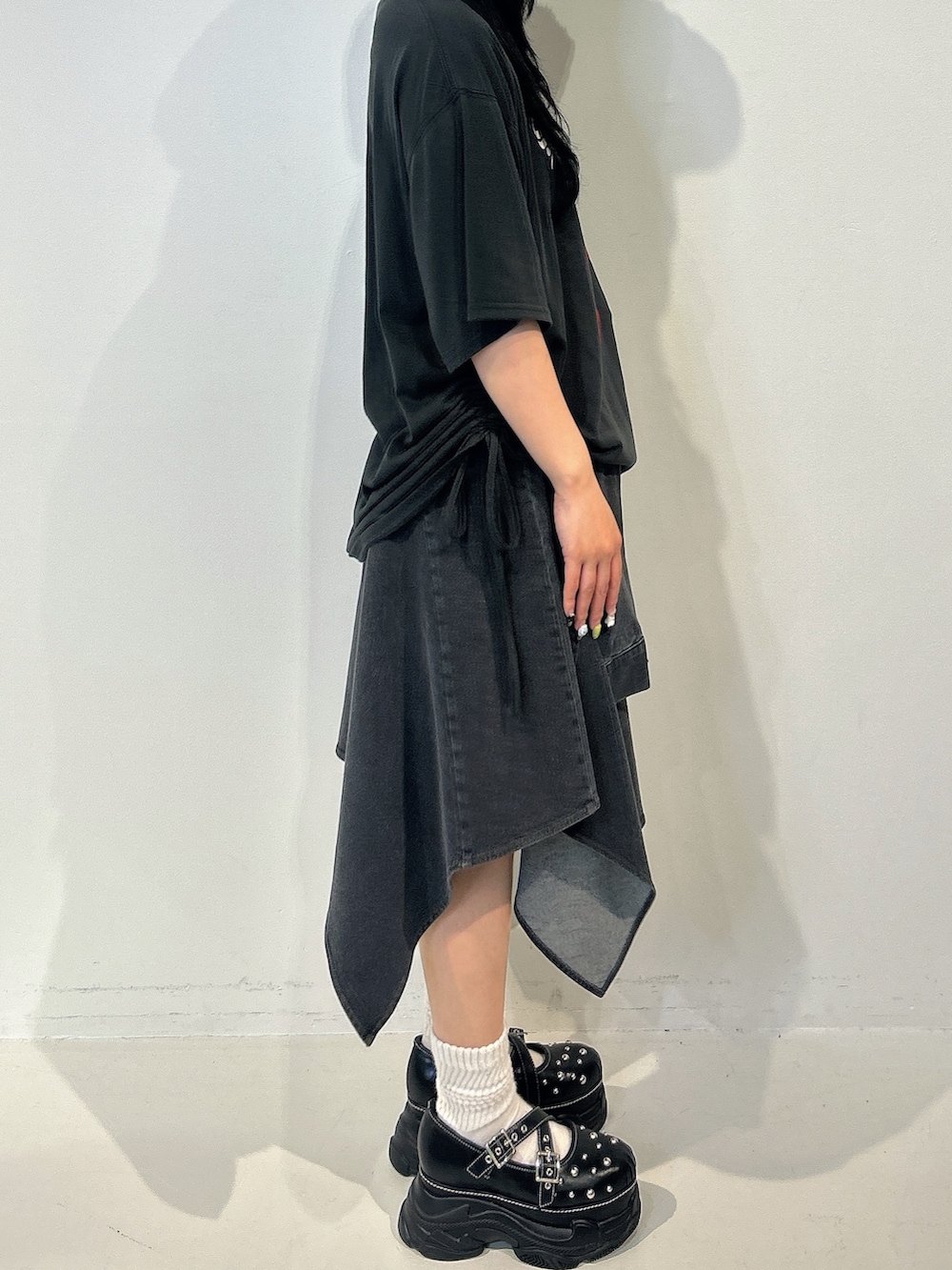 ブラック系のTシャツ/カットソー、ブラック系のスカート、ブラック系のサンダルを着用したレディースの春コーディネートの2枚目の写真