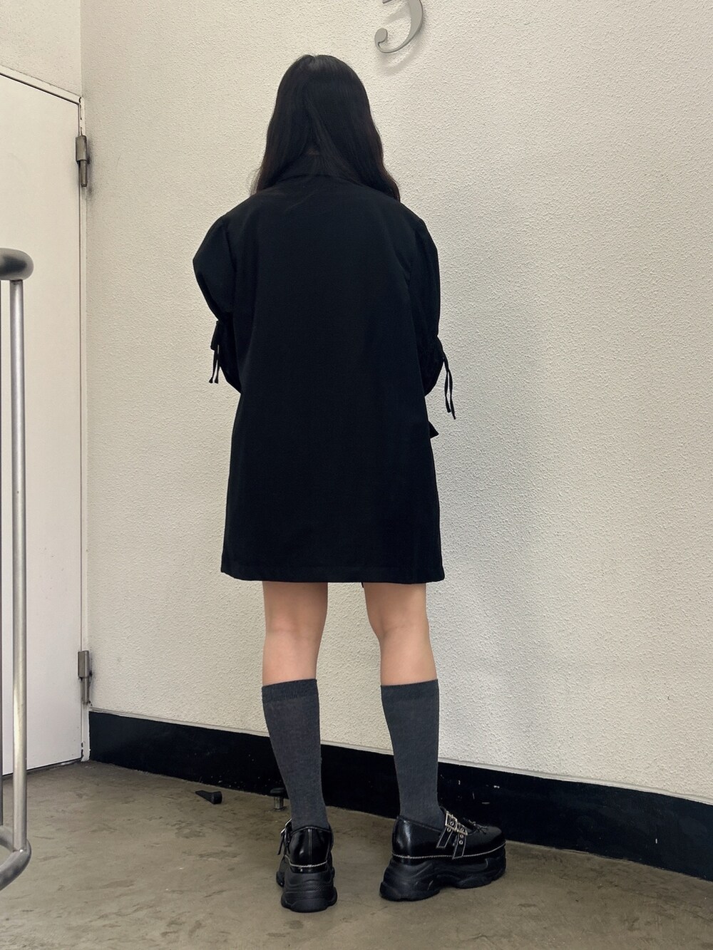 ブラック系のワンピース、ブラック系のスニーカー、ホワイト系のTシャツ/カットソーを着用したレディースの秋コーディネートの3枚目の写真