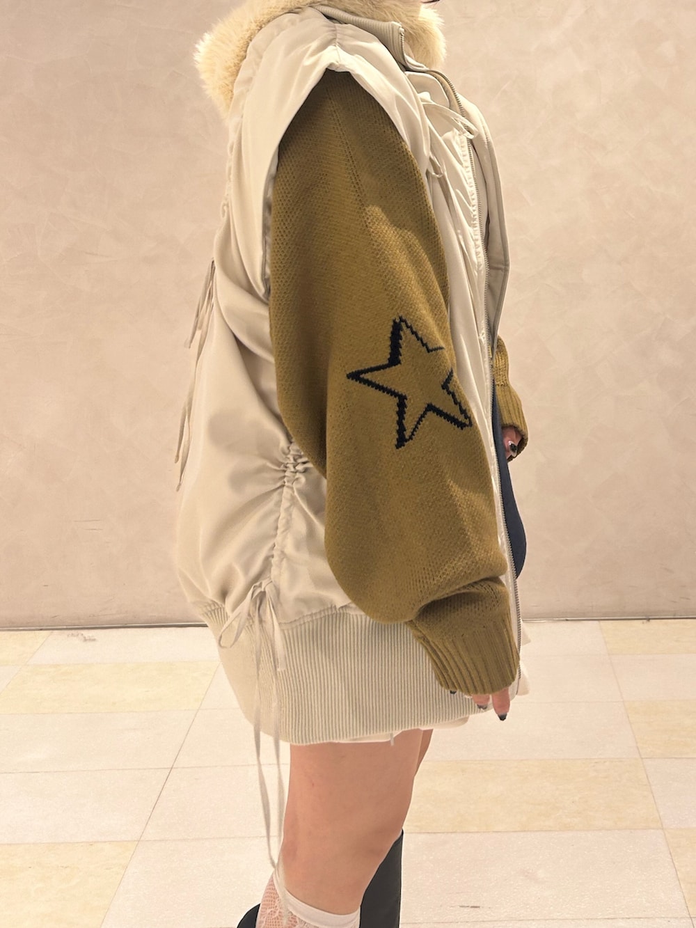 ブルー系のニット/セーター、ホワイト系のスカート、ホワイト系のダウンベストを着用したレディースの冬コーディネートの7枚目の写真