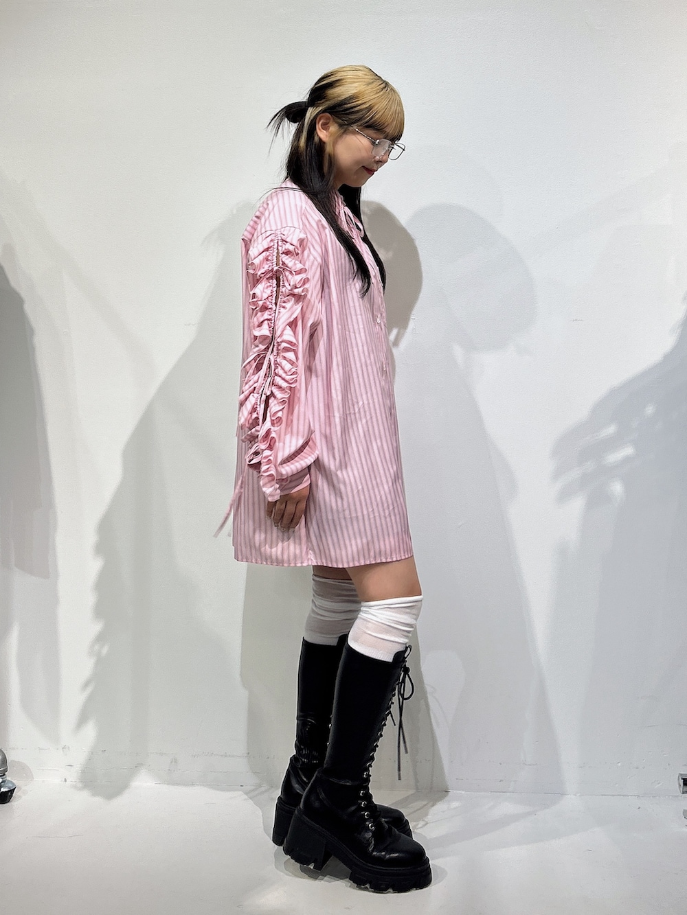 ピンク系のシャツ/ブラウス、ブラック系のブーツを着用したレディースの冬コーディネートの2枚目の写真