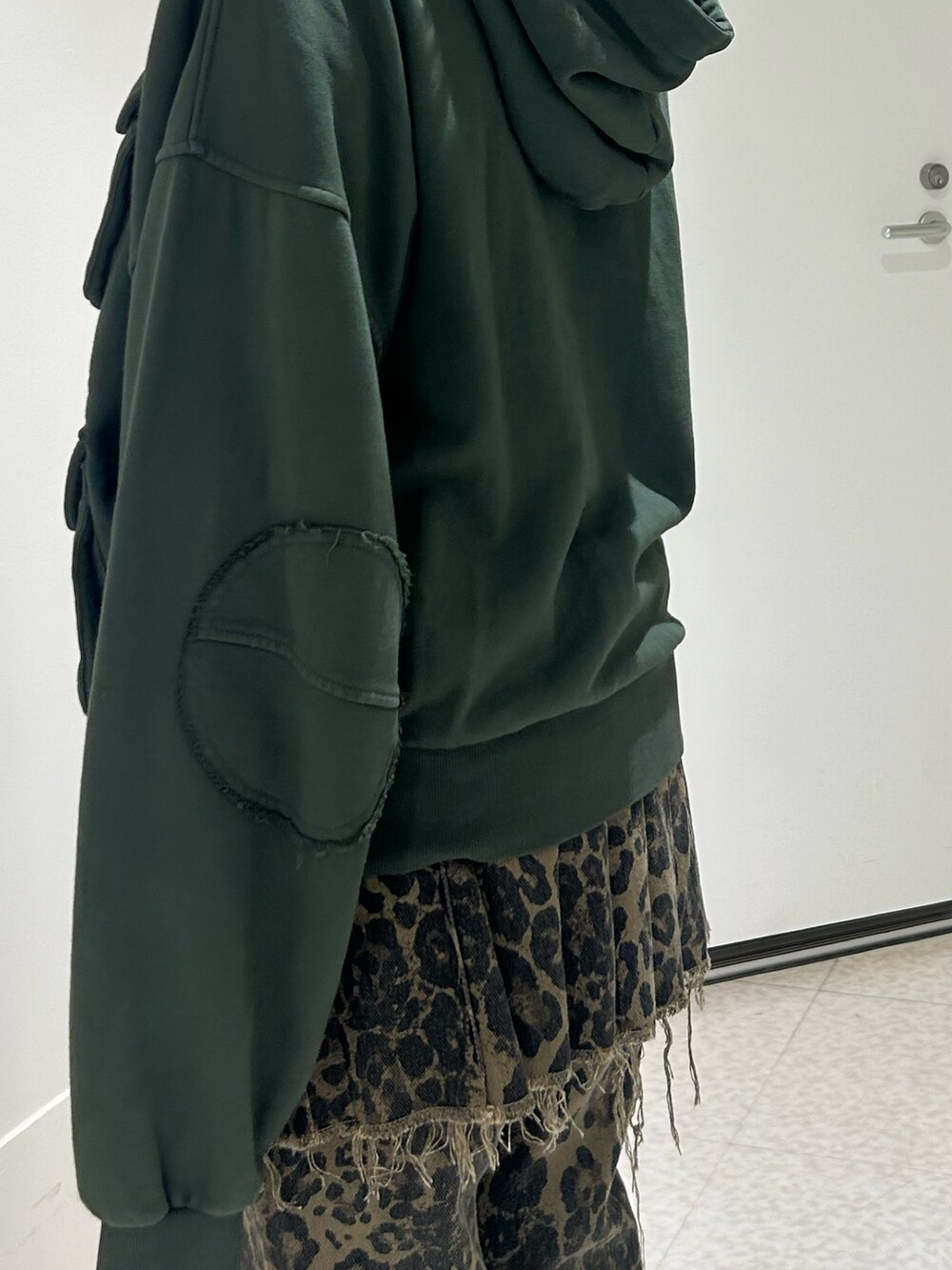 ブラウン系のその他パンツ、ブラック系のドレスシューズ、グリーン系のパーカーを着用したレディースの秋コーディネートの5枚目の写真