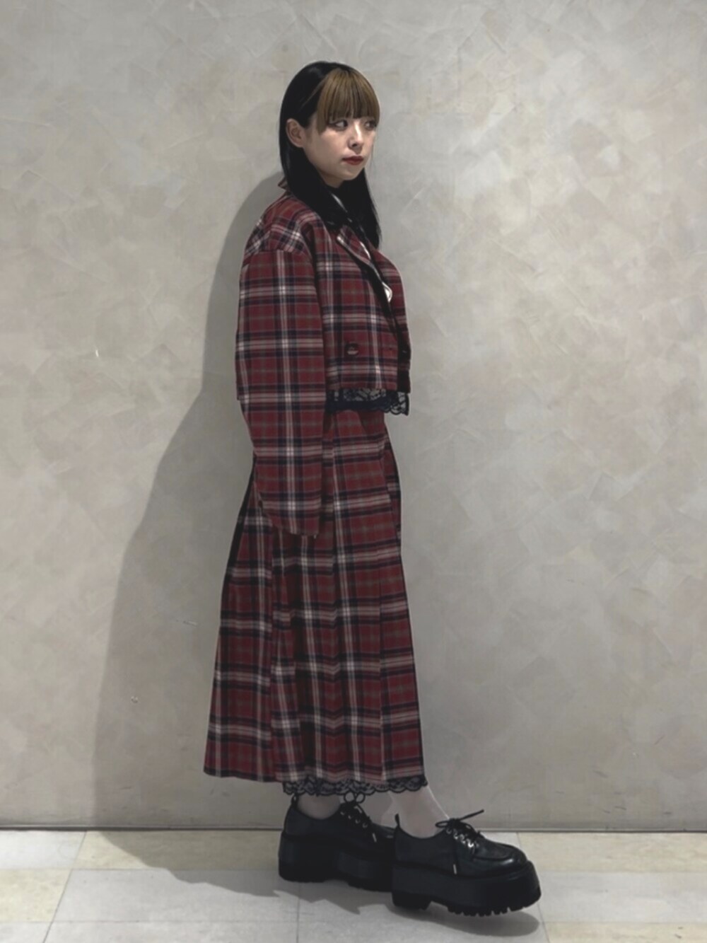 ブラック系のドレスシューズ、ホワイト系のシャツ/ブラウス、レッド系のスカートを着用したレディースの冬コーディネートの2枚目の写真