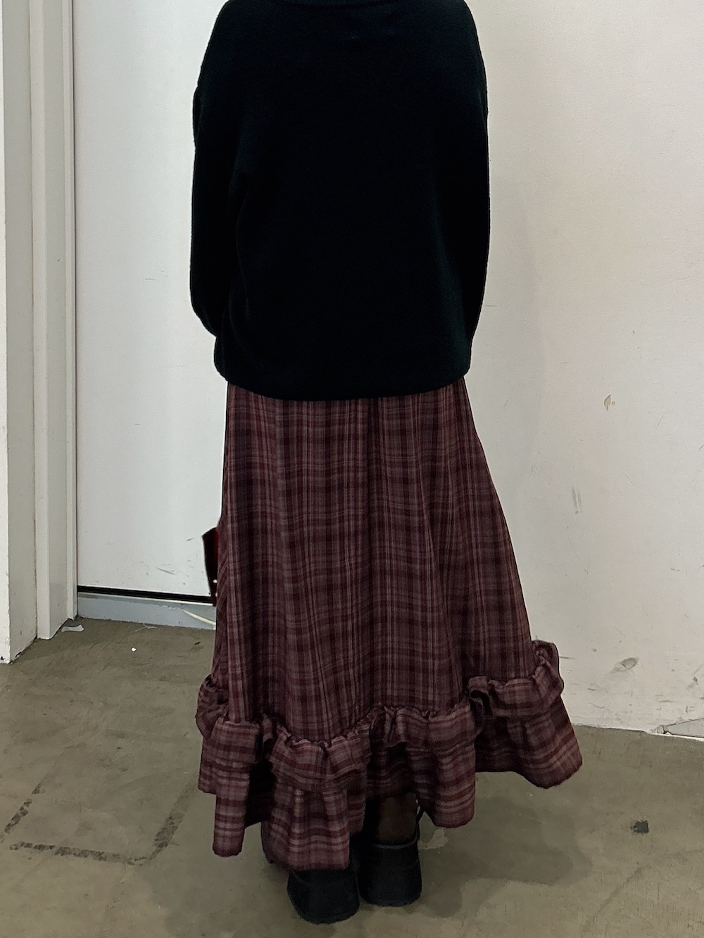 ブラック系のニット/セーター、レッド系のワンピース、レッド系のショルダーバッグを着用したレディースの秋コーディネートの3枚目の写真