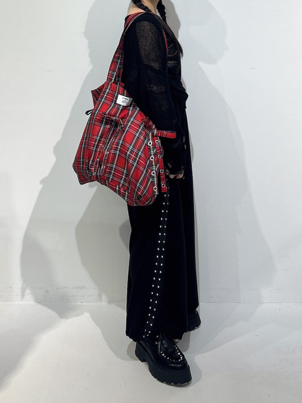 ブラック系のニット/セーター、ブラック系のスウェットパンツ、ブラック系のローファーを着用したレディースの冬コーディネートの2枚目の写真