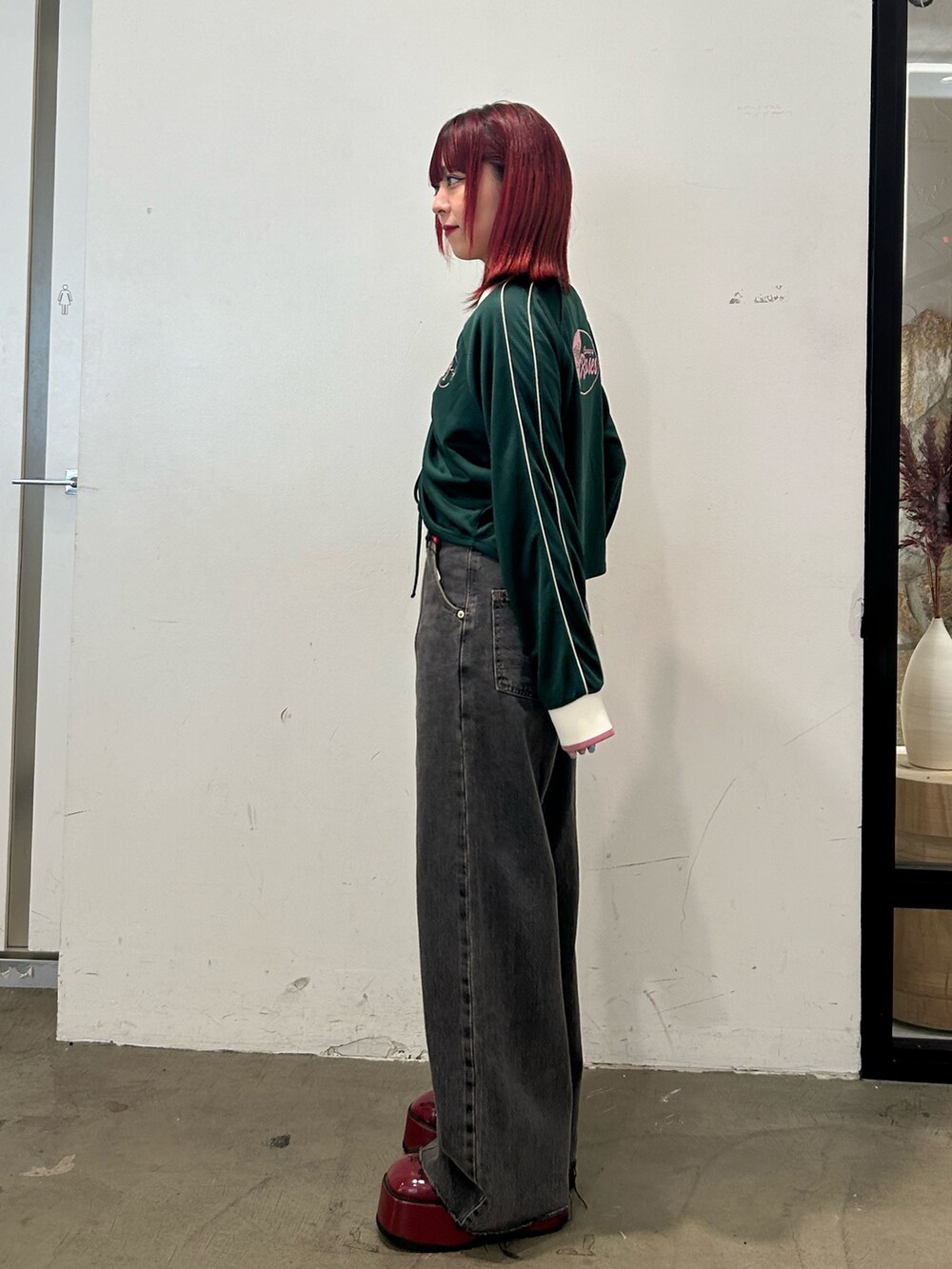 グリーン系のTシャツ/カットソー、ブラック系のデニムパンツ、レッド系のローファーを着用したレディースの夏コーディネートの2枚目の写真