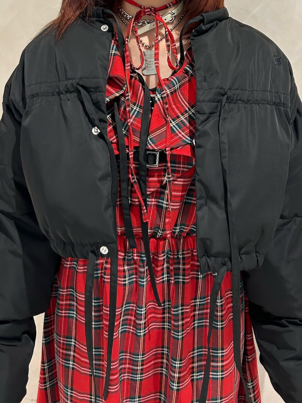 レッド系のワンピース、ブラック系のブルゾン、ブラック系のドレスシューズを着用したレディースの冬コーディネートの6枚目の写真