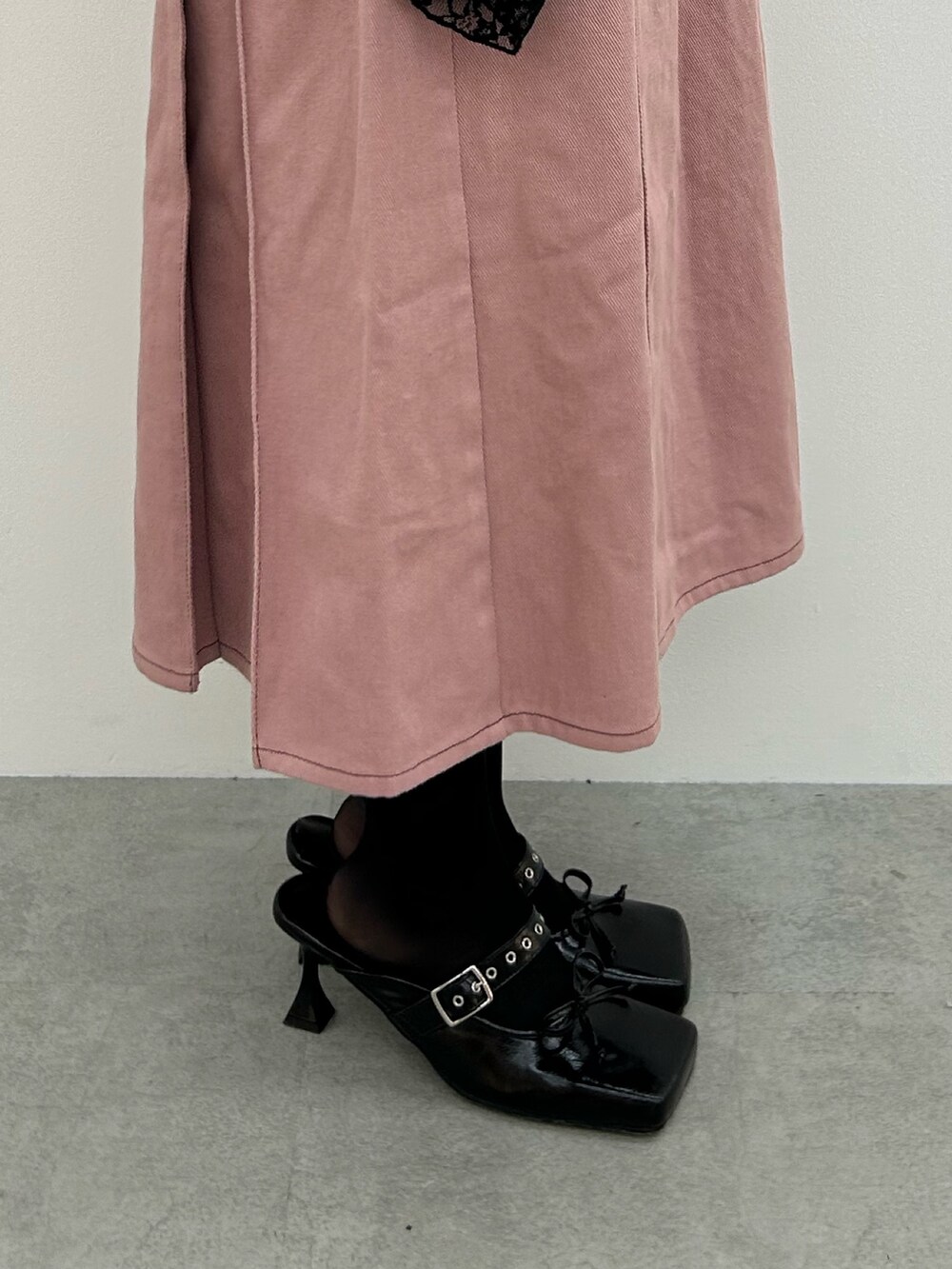 ピンク系のワンピース、ブラック系のパンプス、ブラック系のTシャツ/カットソーを着用したレディースの春コーディネートの7枚目の写真