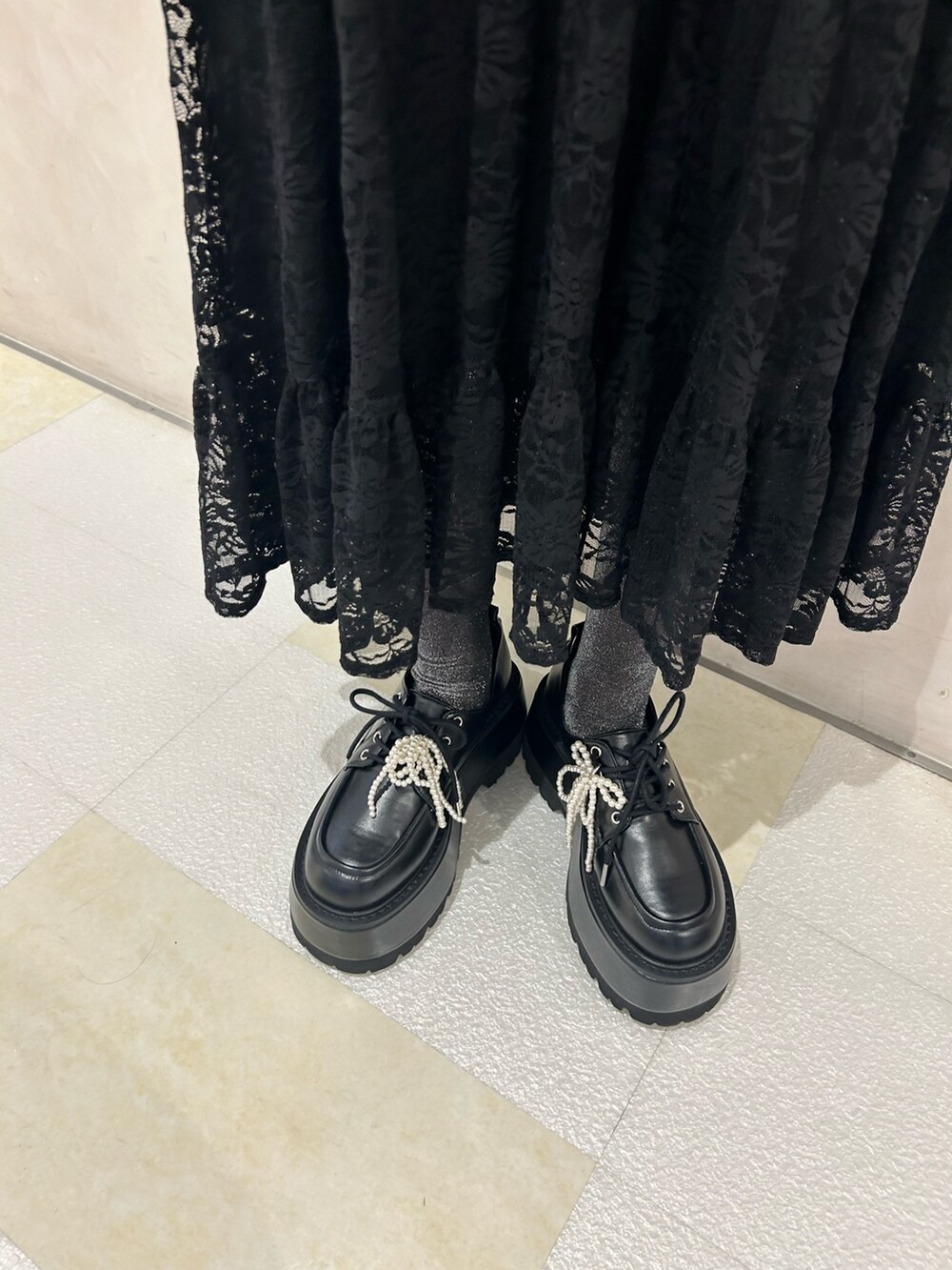 ブラック系のスカート、ブラック系のドレスシューズ、ホワイト系のシューズ小物/雑貨を着用したレディースの秋コーディネートの9枚目の写真