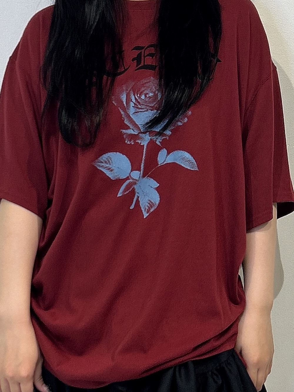 レッド系のTシャツ/カットソー、ブラック系のスカート、ブラック系のハンドバッグを着用したレディースの春コーディネートの5枚目の写真