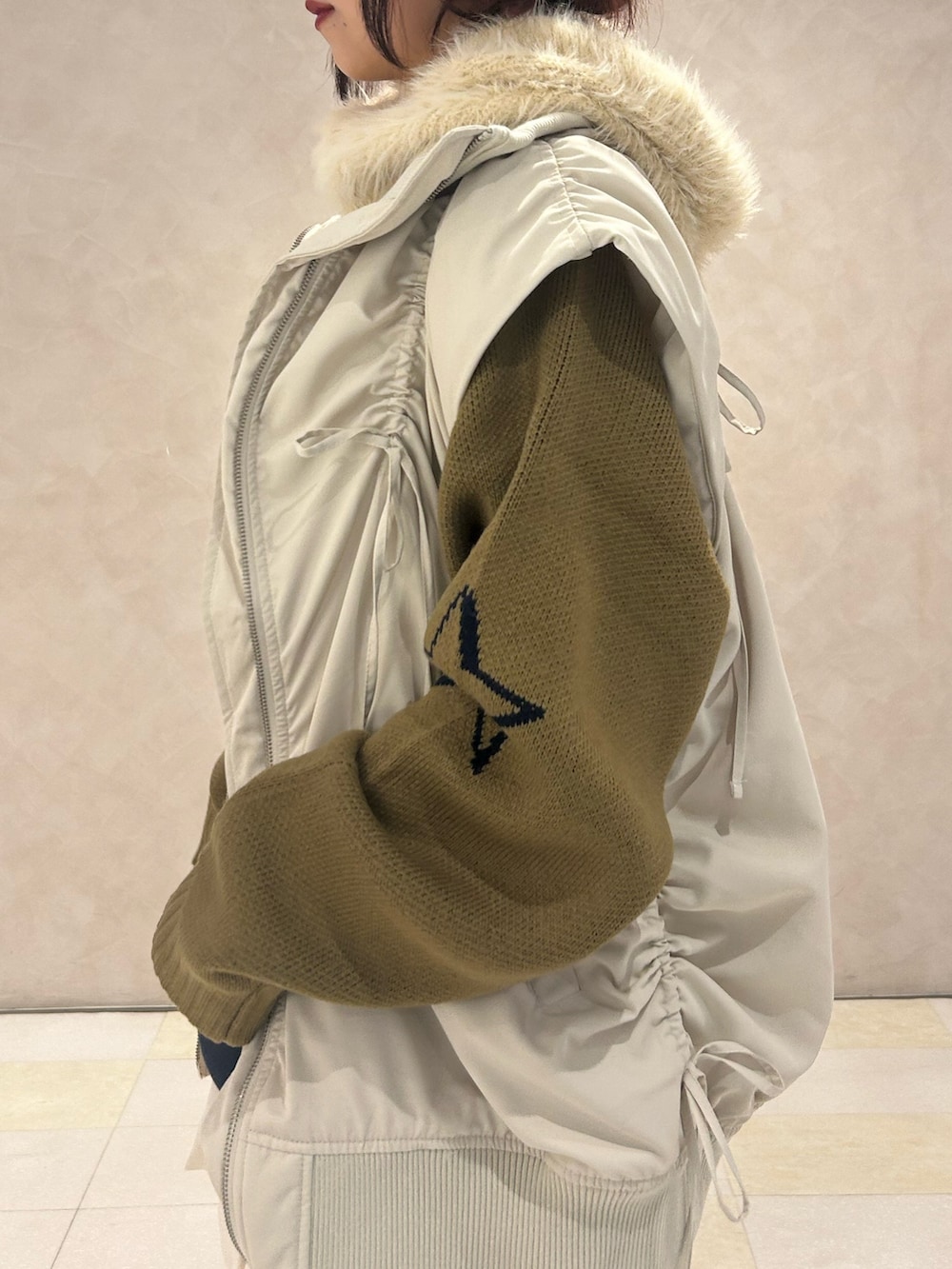 ブルー系のニット/セーター、ホワイト系のスカート、ホワイト系のダウンベストを着用したレディースの冬コーディネートの5枚目の写真