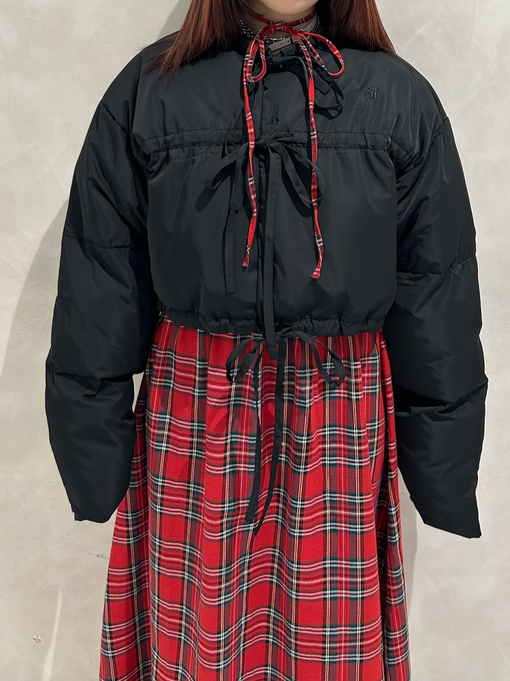 レッド系のワンピース、ブラック系のブルゾン、ブラック系のドレスシューズを着用したレディースの冬コーディネートの4枚目の写真